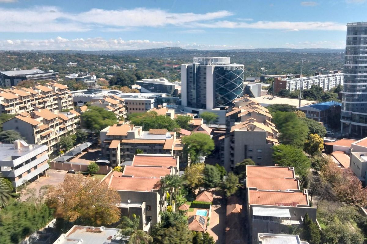 An elevated aerial view showcasing the surrounding urban landscape, residential apartment complexes, and commercial buildings in the neighborhood.