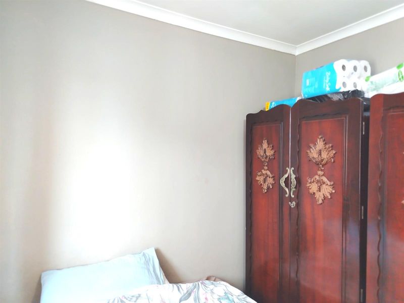 A bedroom interior featuring neutral wall paint and decorative coving.