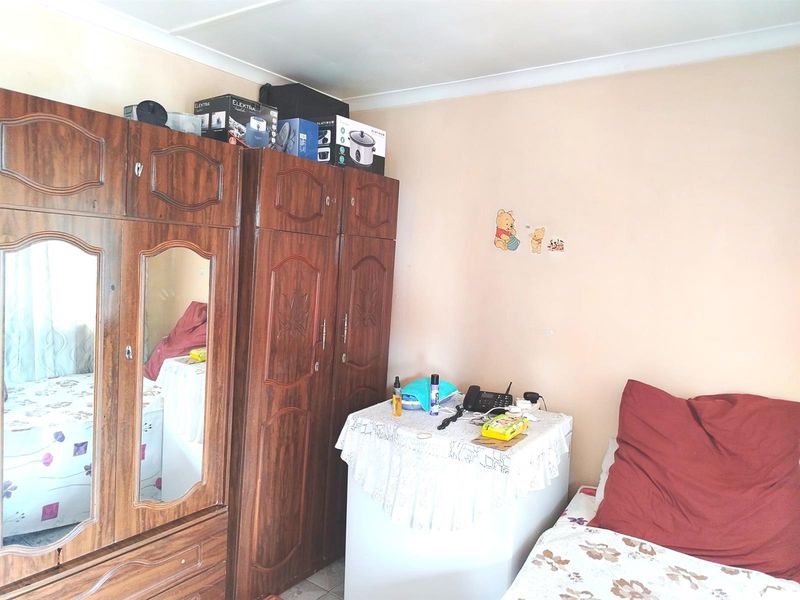 A bedroom featuring a large wooden built-in wardrobe with mirrored panels and coved ceiling detailing.