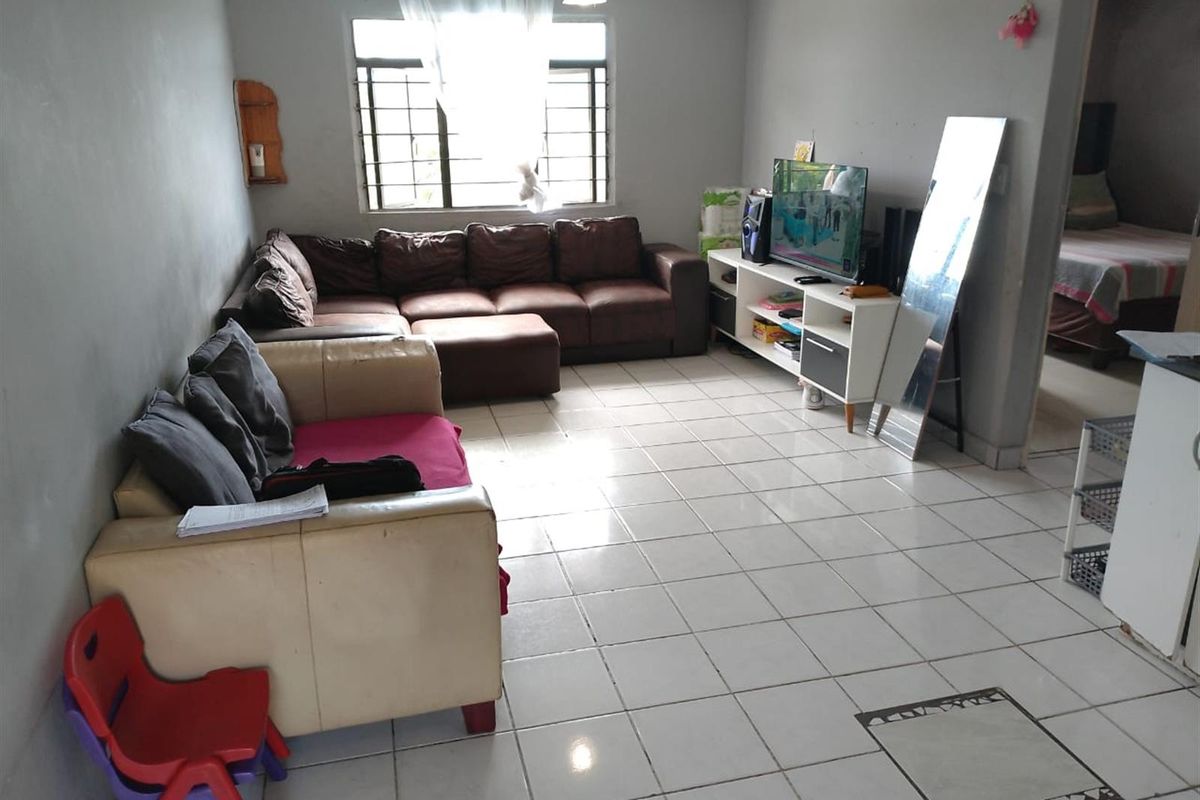 A living room featuring tiled flooring, a ceiling fan, and a window with security bars, offering a functional space for relaxation.