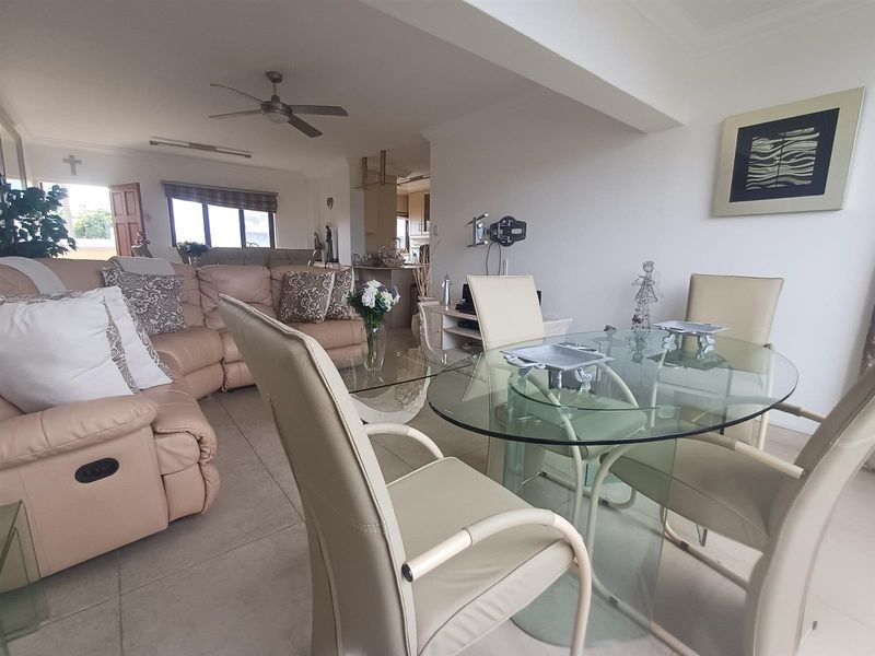 Open plan living and dining area featuring tiled flooring, a ceiling fan, and a seamless flow into the adjacent kitchen space.