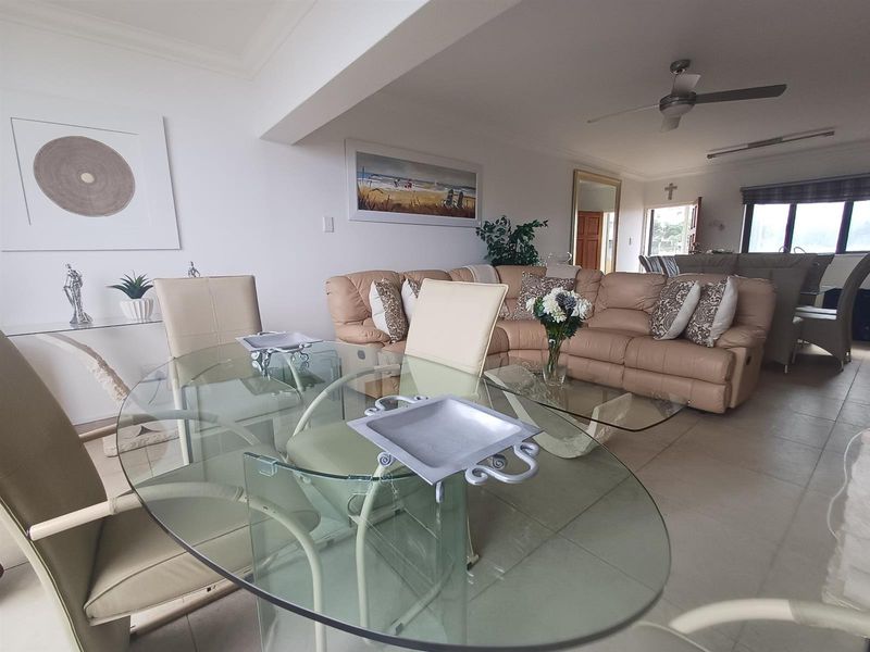 Spacious open-plan living and dining area featuring neutral floor tiles, a ceiling fan, and a seamless flow between the lounge and dining space.