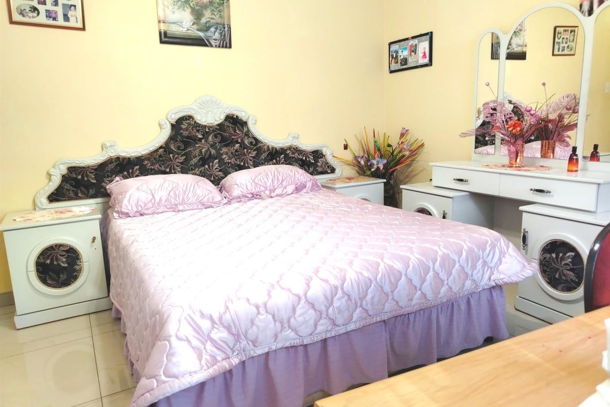 A bedroom featuring tiled flooring and neutral wall finishes, providing a functional space for rest.