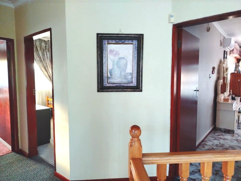 A hallway area featuring timber door frames and a wooden balustrade, providing access to adjacent rooms.