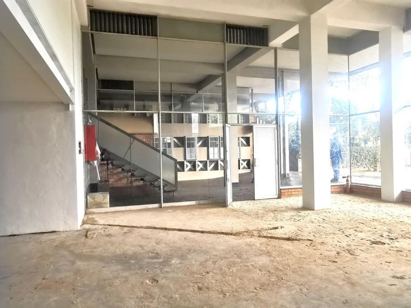 Spacious commercial interior featuring floor-to-ceiling glass windows, structural concrete columns, and an open-plan layout ready for custom fit-out.