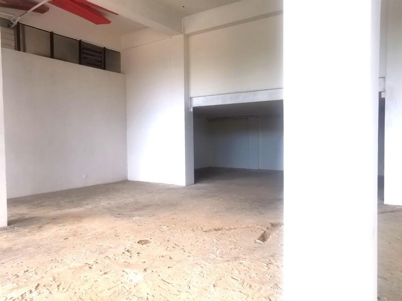 An expansive, empty commercial open-plan space featuring high ceilings, structural support columns, and large windows, suitable for a variety of business configurations.