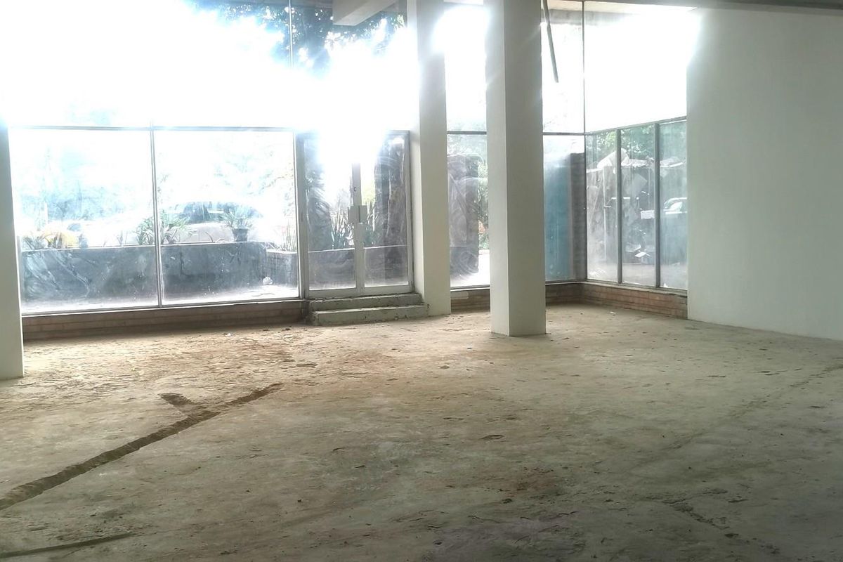 An expansive, open-plan commercial space featuring floor-to-ceiling glass windows, structural columns, and unfinished concrete flooring, offering a blank canvas for custom fit-out.