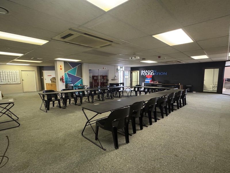 Spacious commercial office area featuring a suspended ceiling with recessed lighting, ducted air conditioning, and carpeted flooring, suitable for a collaborative workspace.