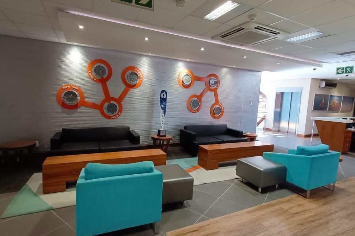 A modern commercial reception and waiting area featuring a textured feature wall, recessed ceiling lighting, and integrated air conditioning unit.
