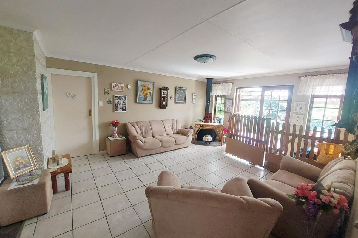 Spacious living room featuring tiled flooring, a fireplace, and large sliding glass doors providing natural light and access to the outdoor area.