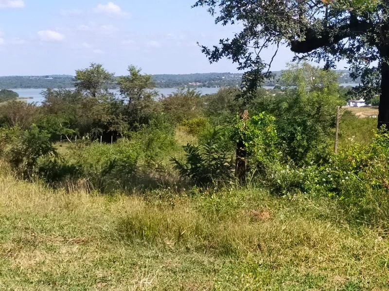 A scenic view of the surrounding landscape and distant water body from the vacant commercial land.