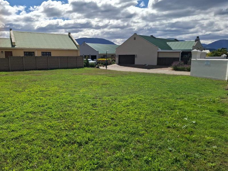 A level, vacant residential plot of land situated within a developed estate, offering a clear building site with established neighbouring properties.