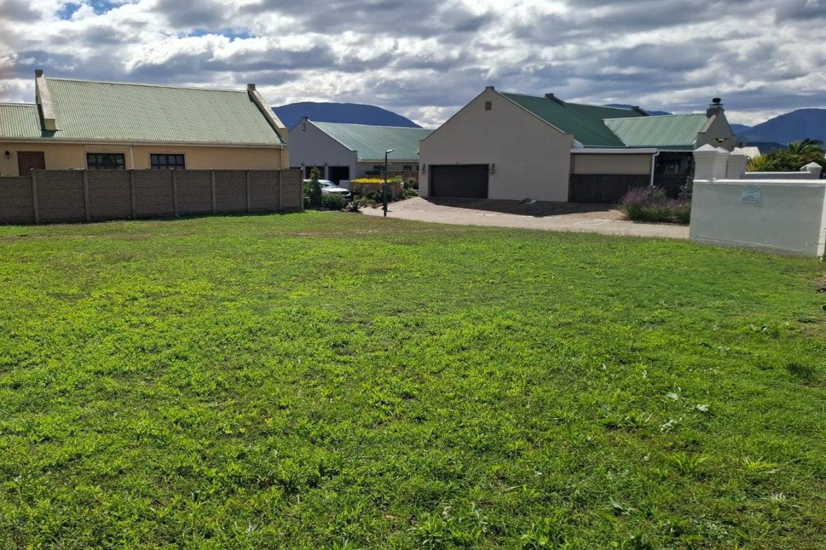 A level, vacant residential plot of land situated within a developed estate, offering a clear building site with established neighbouring properties.