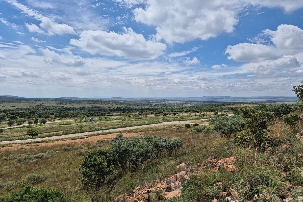 A scenic, elevated view of the surrounding natural landscape, featuring native vegetation, rocky terrain, and expansive open space.
