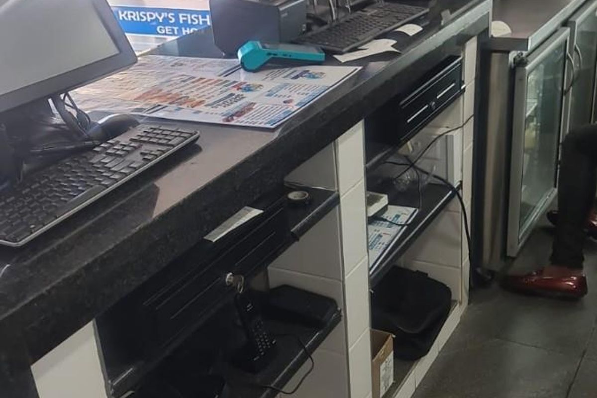 A functional restaurant service counter featuring a stone countertop, tiled base, and integrated under-counter refrigeration units for efficient food service operations.