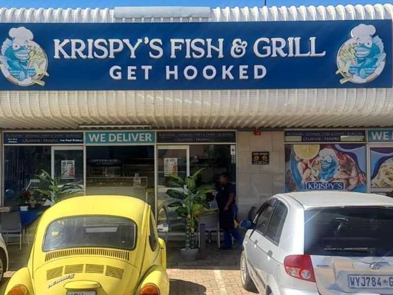 Front exterior view of Krispy's Fish & Grill restaurant featuring prominent signage and a paved parking area.