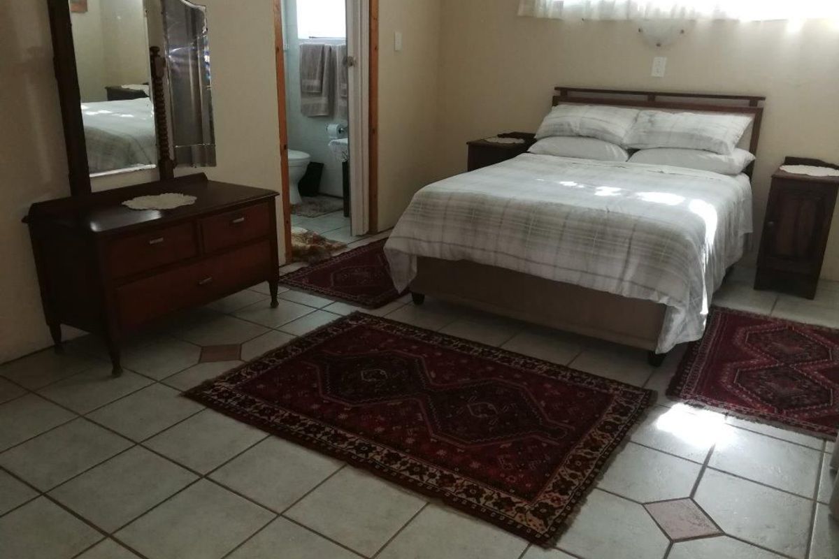 A bedroom featuring tiled flooring and an en-suite bathroom, providing a functional and comfortable living space.