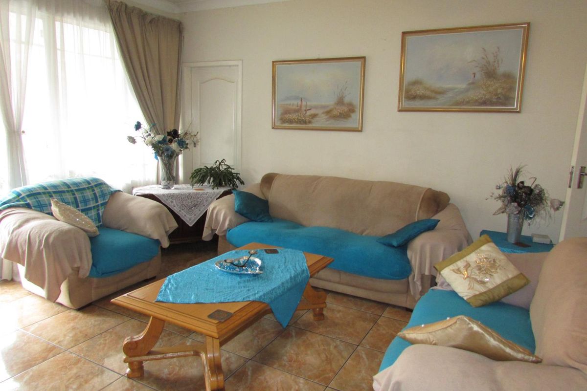 A comfortable living room featuring tiled flooring and large windows that allow for ample natural light.