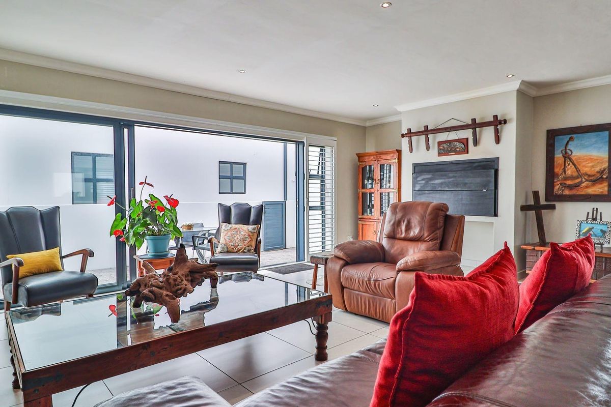Spacious living room featuring large sliding glass doors that open onto an outdoor patio area, providing excellent natural light and seamless indoor-outdoor flow.