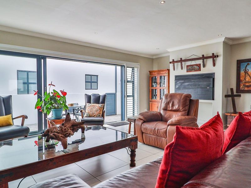 Spacious living room featuring large sliding glass doors that open onto an outdoor patio area, providing excellent natural light and seamless indoor-outdoor flow.