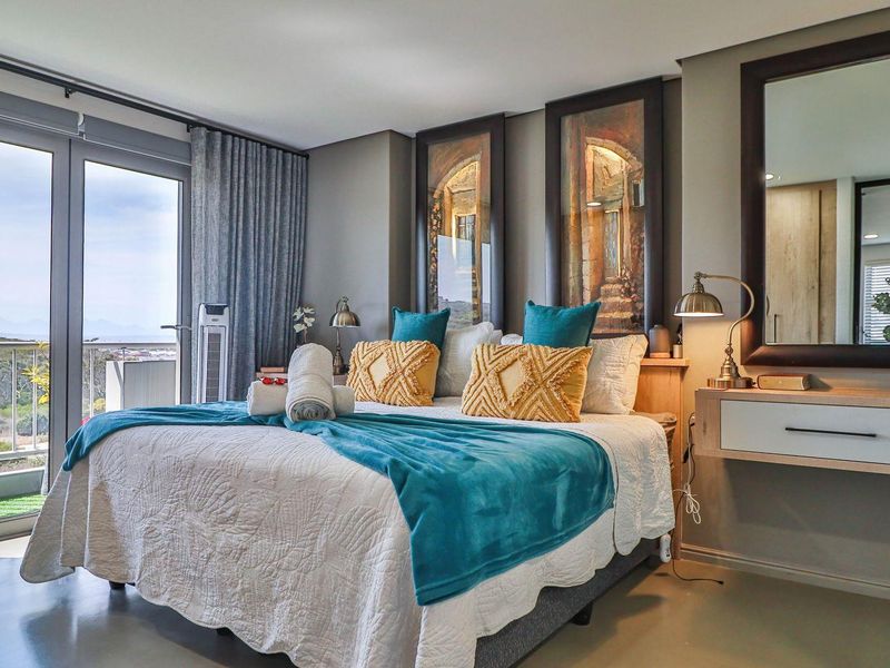 A well-maintained bedroom featuring a floating vanity, large glass sliding doors leading to a balcony, and neutral wall finishes.