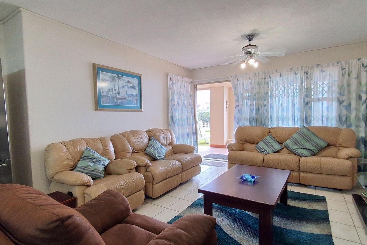 Spacious living room featuring tiled flooring, a ceiling fan, and sliding glass doors providing direct access to an outdoor patio area.