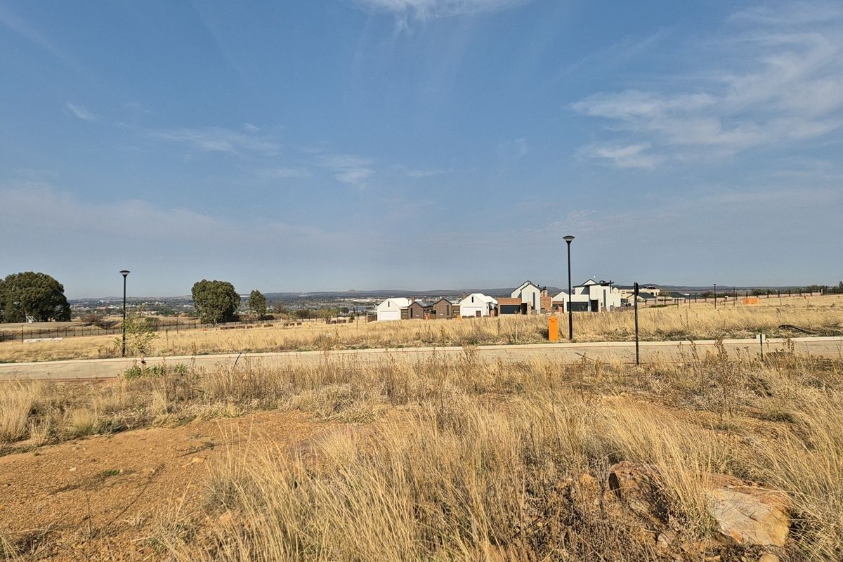 A wide-angle view of the vacant residential land, featuring established street infrastructure, perimeter fencing, and surrounding estate development.