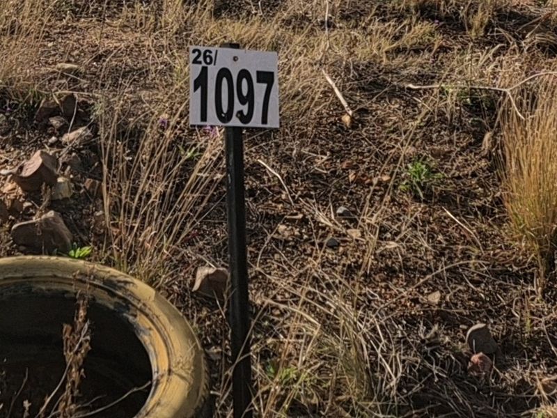A close-up view of a property marker stake on a vacant residential plot.