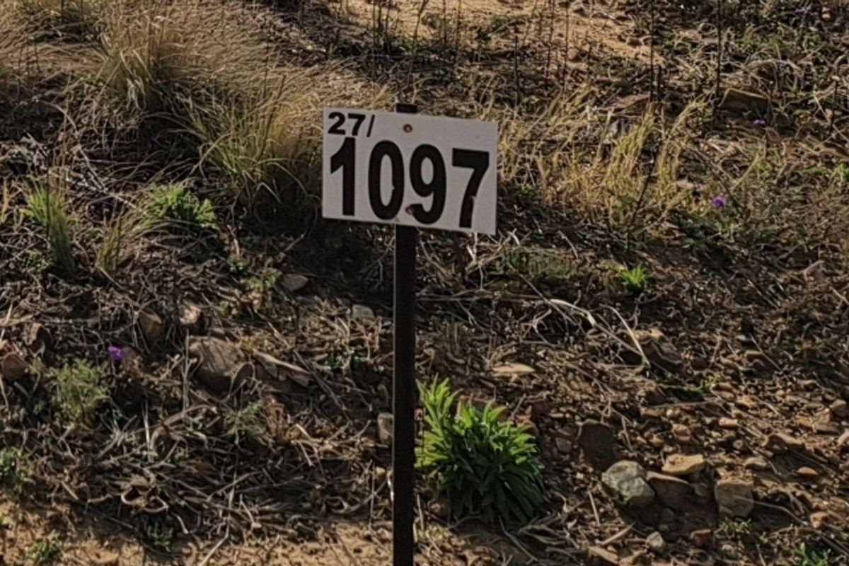 A close-up view of a property marker sign indicating lot number 1097 on a vacant residential plot.