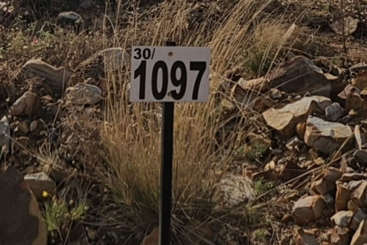 A close-up view of a property boundary marker stake on a vacant residential plot.
