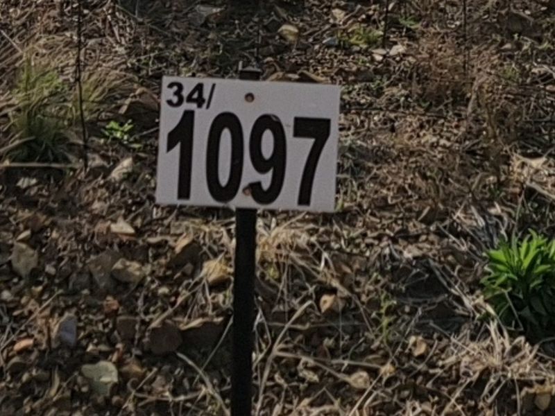 A close-up view of a property identification marker on a vacant residential plot.