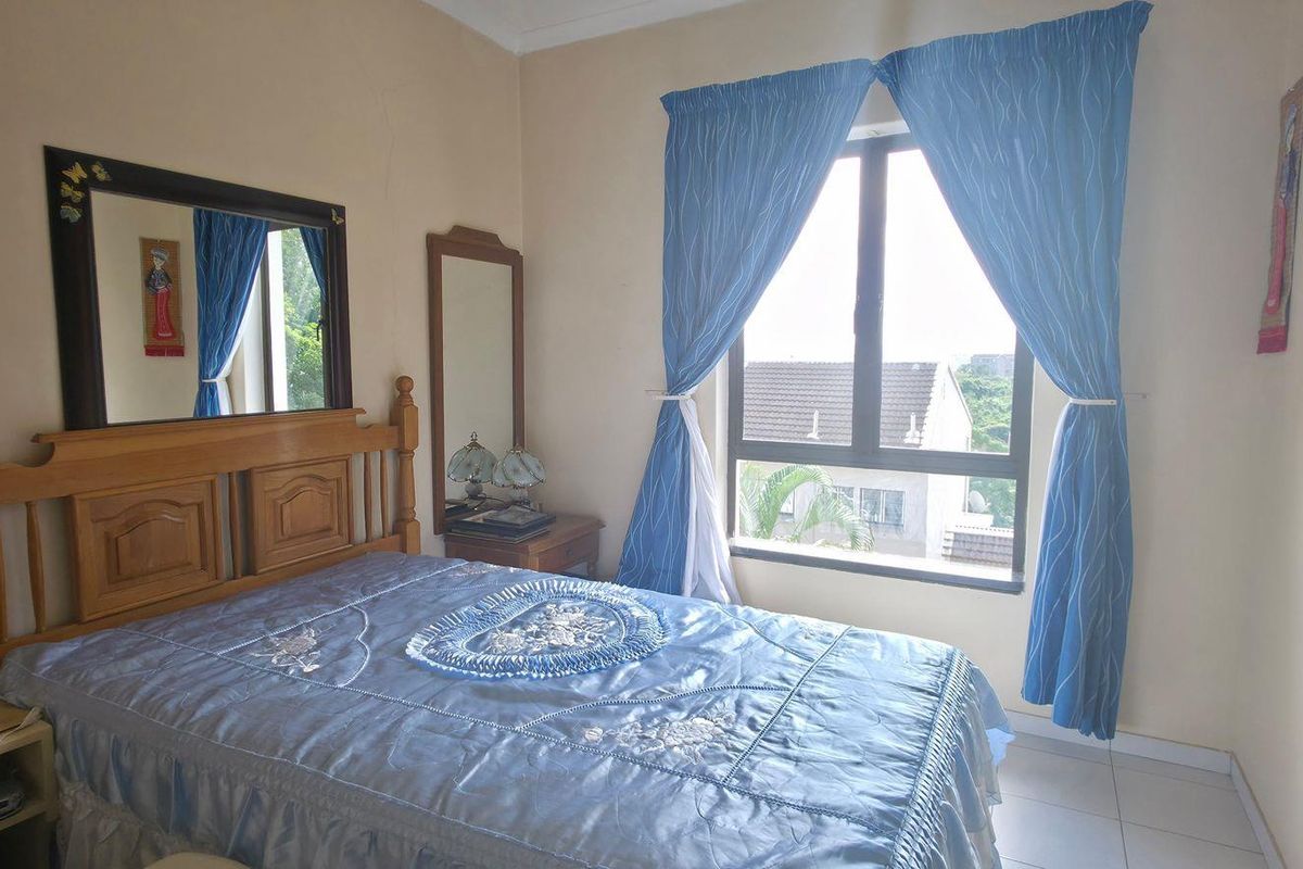 A standard bedroom featuring tiled flooring and an aluminium window frame, offering a functional space with potential for modern updates.