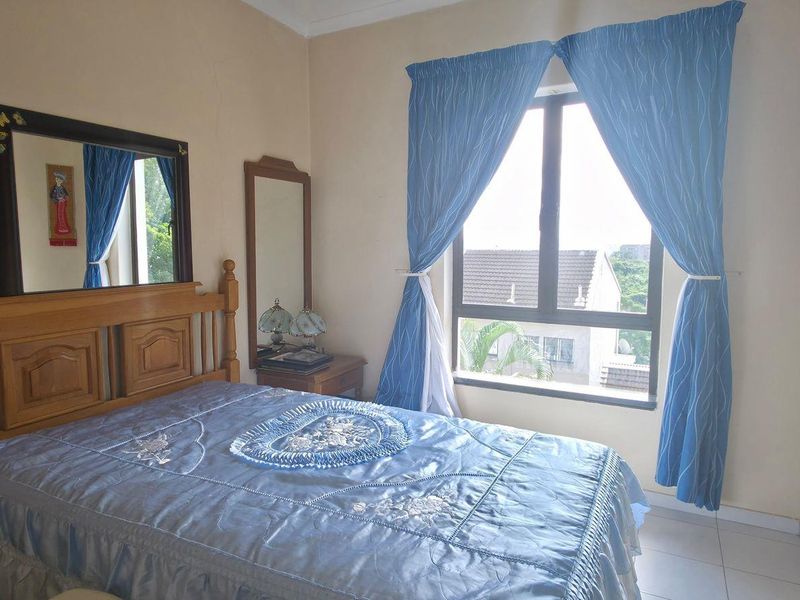 A standard bedroom featuring tiled flooring and an aluminium window frame, offering a functional space with potential for modern updates.