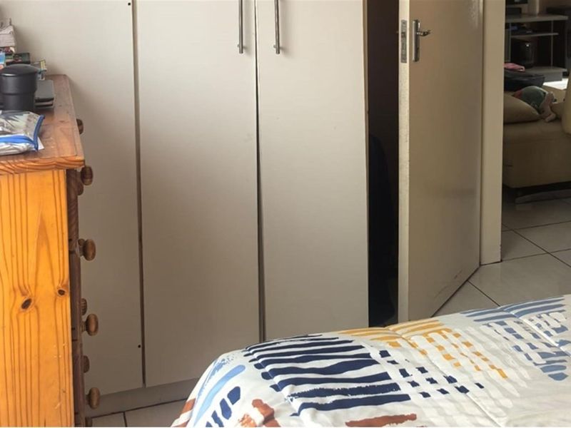 A bedroom featuring built-in cupboards and tiled flooring, providing functional storage and a neutral base for interior design.