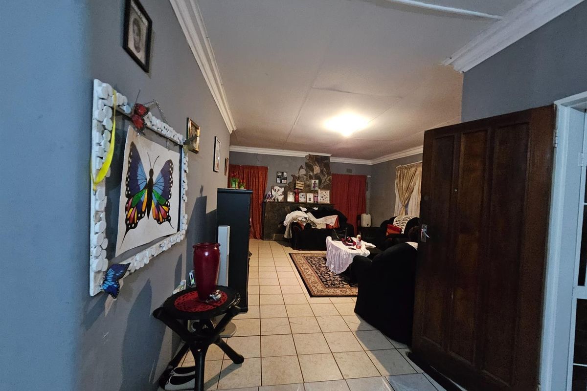 A spacious living room featuring tiled flooring, a built-in fireplace, and crown molding, offering a comfortable and functional living area.