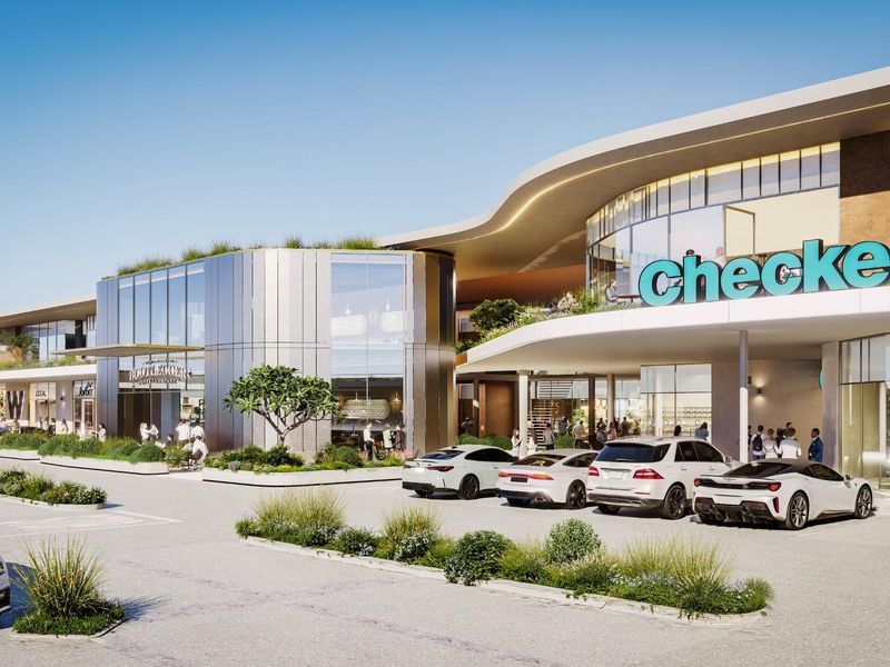 A modern commercial shopping center exterior featuring contemporary architectural design, glass facades, and integrated parking facilities.