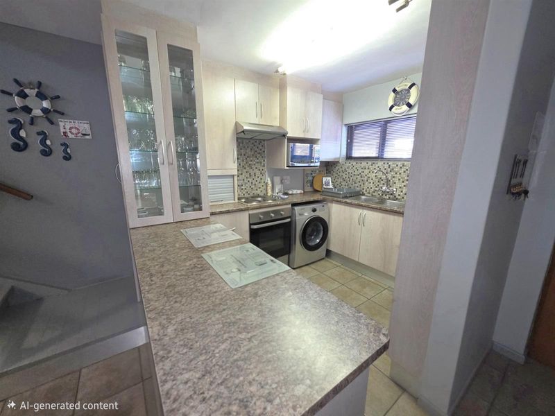 Compact kitchen featuring light wood-finish cabinetry, mosaic tile backsplash, integrated oven, hob, extractor fan, and space for a washing machine.