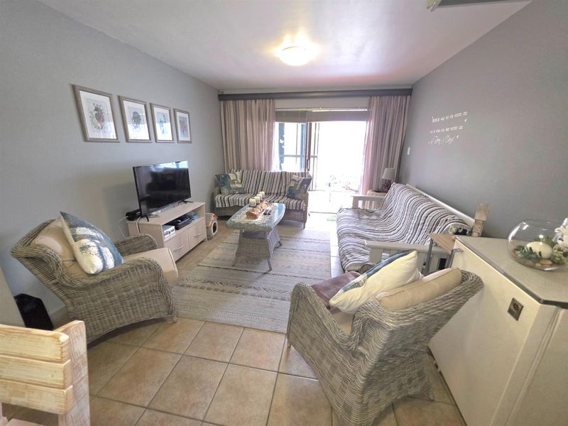 A comfortable living room featuring tiled flooring and sliding glass doors that provide access to an outdoor patio area.