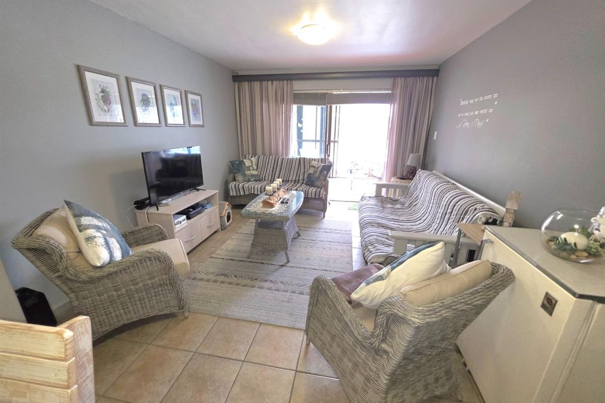 A comfortable living room featuring tiled flooring and sliding glass doors that provide access to an outdoor patio area.