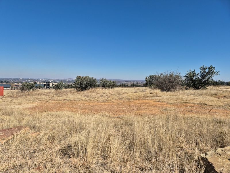 A wide-angle view of the vacant residential land, showcasing the natural terrain, native vegetation, and distant horizon.