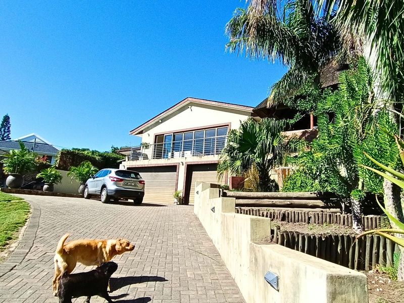 Front view of the property featuring a paved driveway, double garage, and an elevated balcony with a metal balustrade.