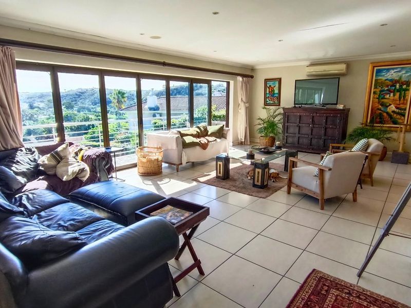 Spacious living room featuring large sliding glass doors that provide natural light and access to an outdoor balcony with scenic views.