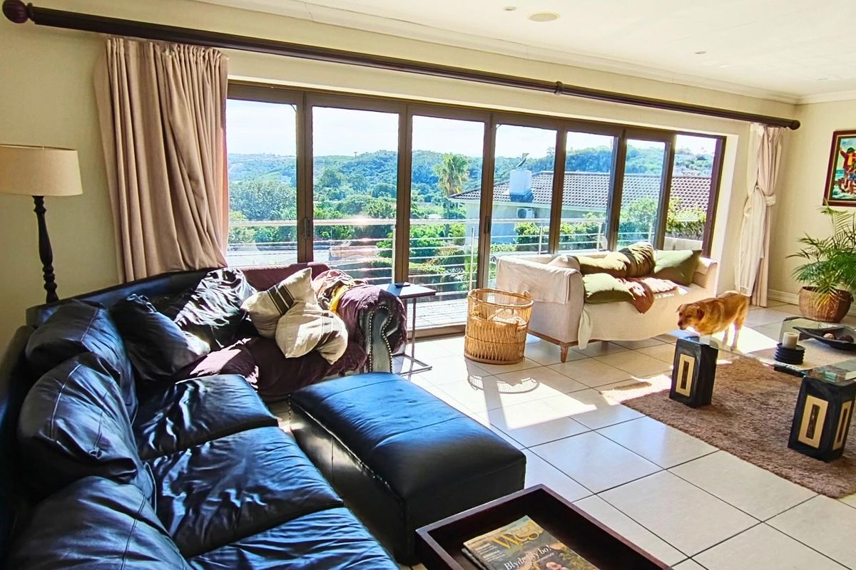 Spacious living room featuring large aluminium sliding doors that provide abundant natural light and expansive views of the surrounding landscape.
