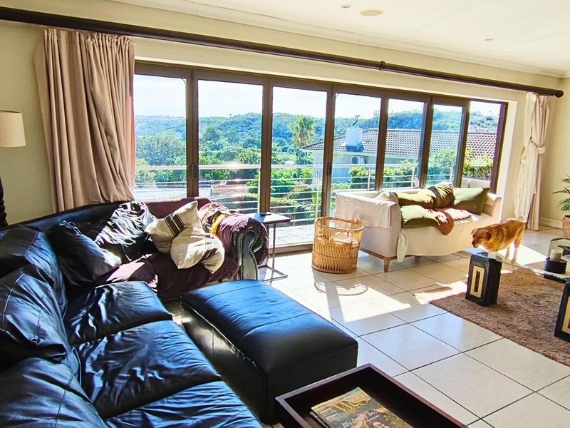 Spacious living room featuring large aluminium sliding doors that provide abundant natural light and expansive views of the surrounding landscape.