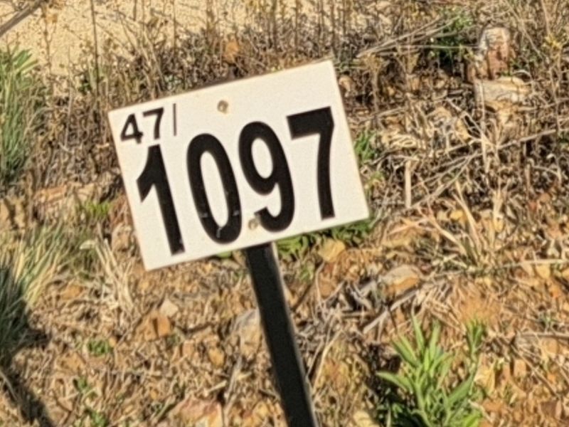A close-up view of a property identification marker on a vacant residential plot.