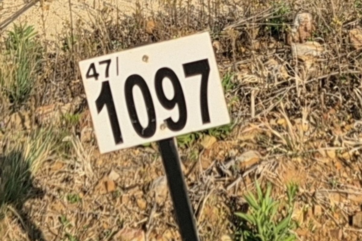 A close-up view of a property identification marker on a vacant residential plot.
