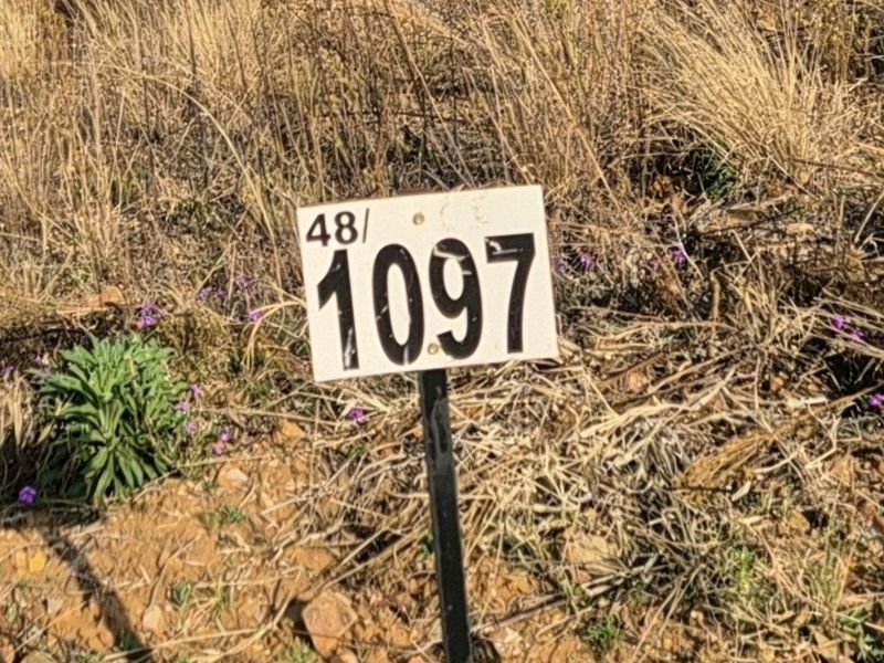 A close-up view of a property identification marker on a vacant residential plot.