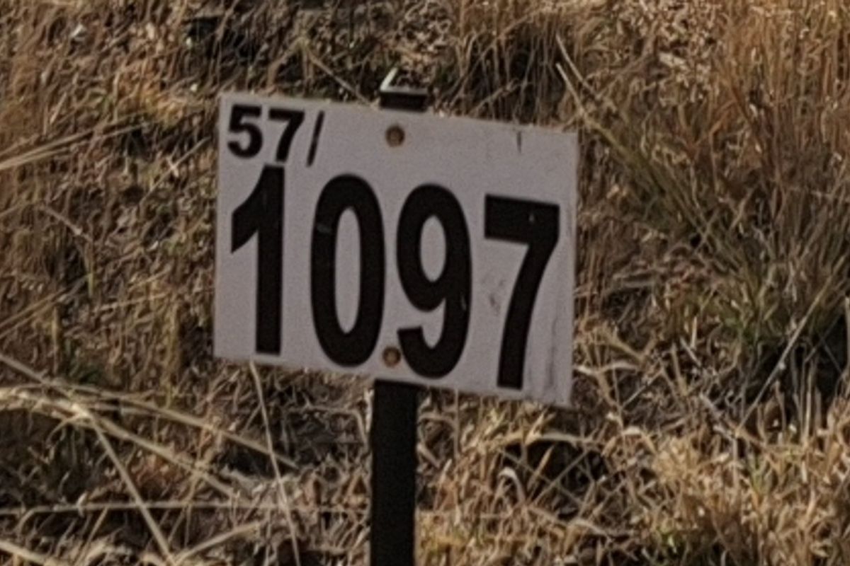 A close-up view of a property identification sign on a vacant residential lot.