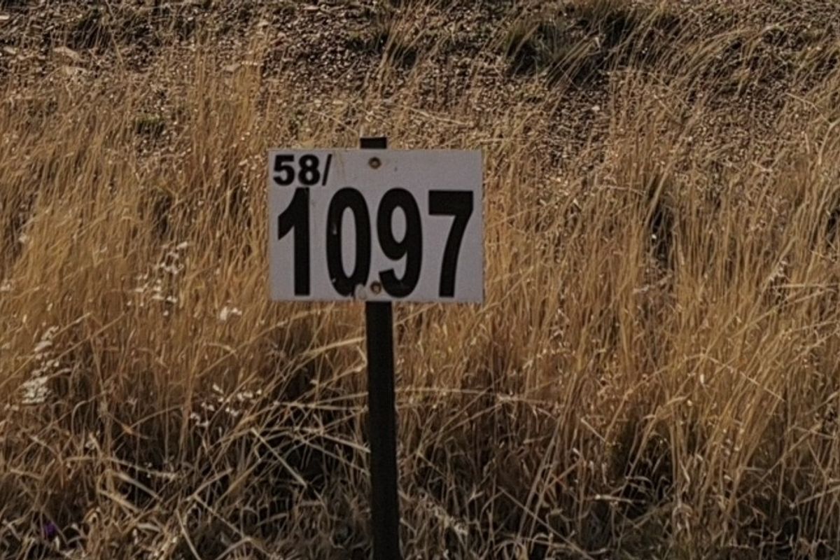 A close-up view of a property identification marker sign situated on a vacant residential lot.