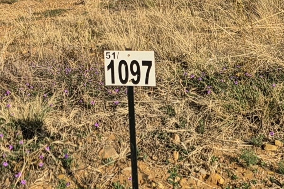 A close-up view of a property boundary marker sign on a vacant residential plot.